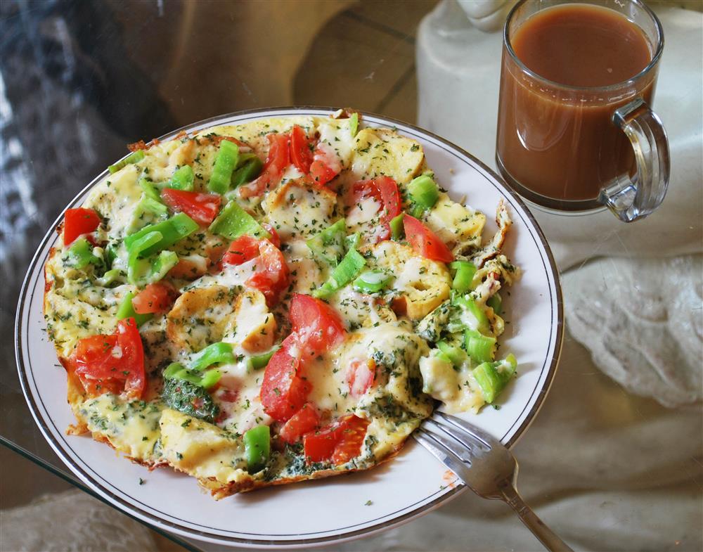 : A plate of omelette with cream and vegetables